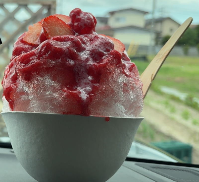 パティスリーリッシュのフレッシュ苺かき氷を竹製スプーンで食べる様子